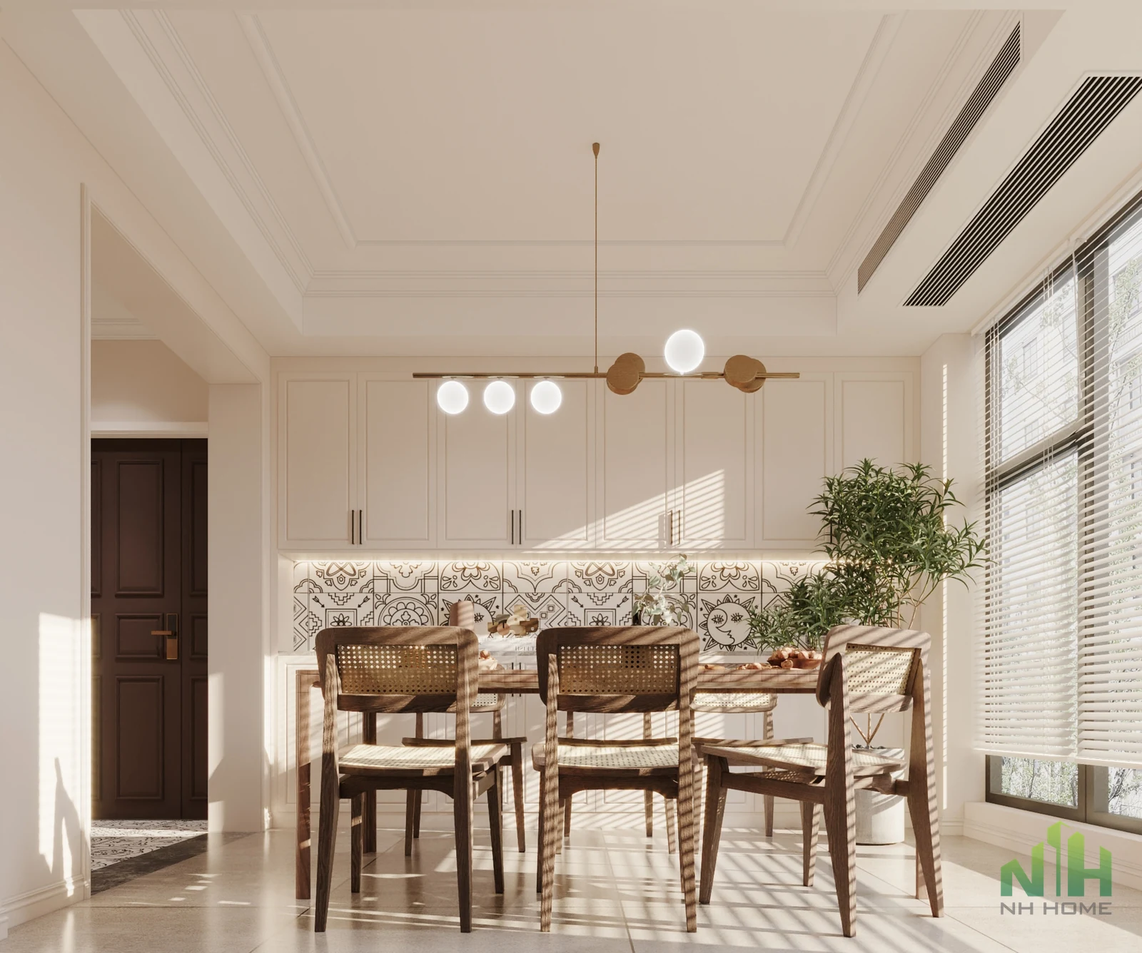 Phòng ăn sáng với bàn ghế gỗ đan mây, tủ màu kem, gạch họa tiết và cửa sổ lớn có rèm sáo.